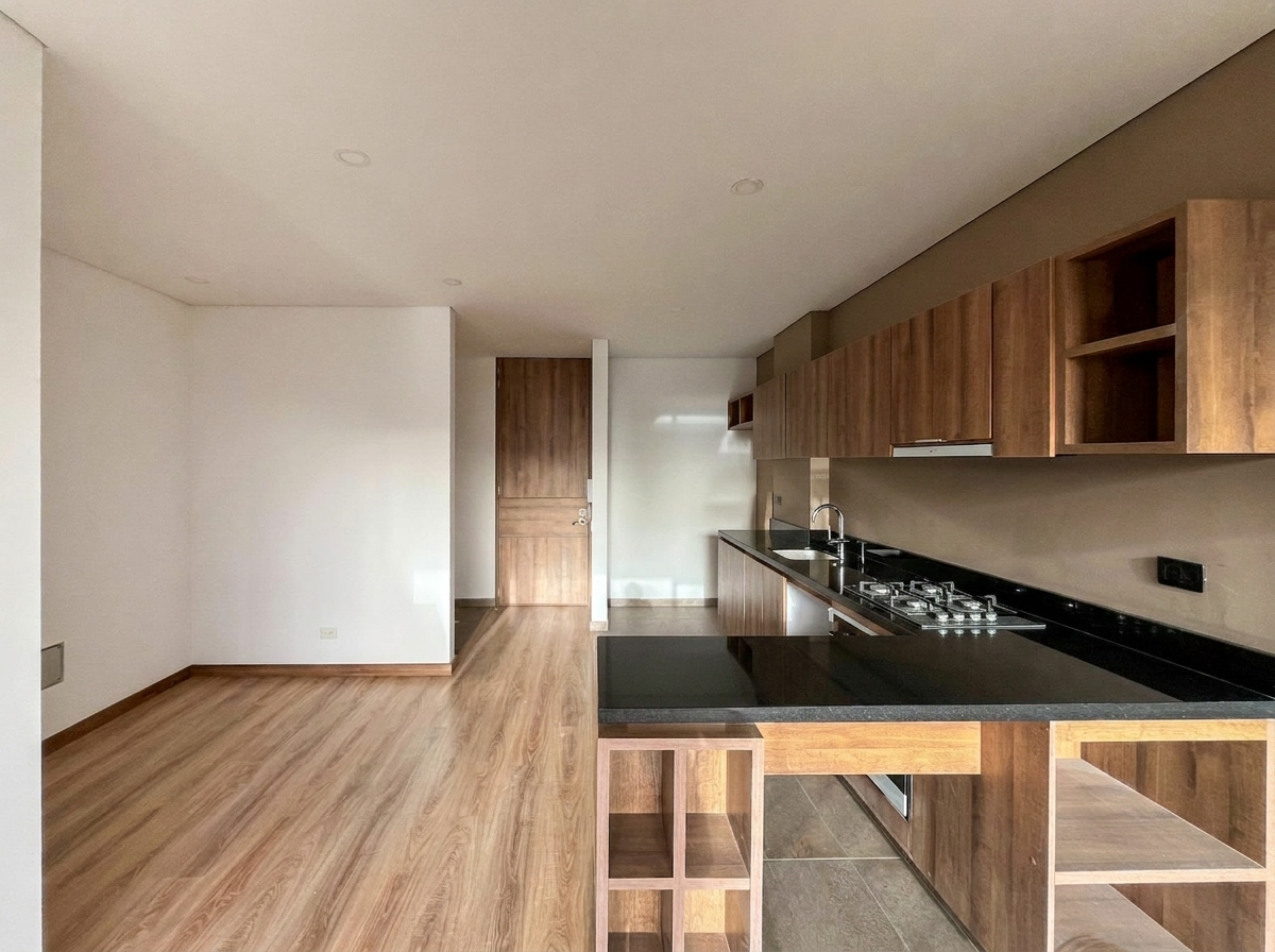 Cocina con mesón en granito negro, cooktop a gas y mobiliario en madera